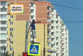 В центре Краснодара парень в неадекватном состоянии залез на дорожный знак