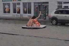Пара в купальных костюмах отдыхает на затопленной улице в посёлке Южном под Краснодаром